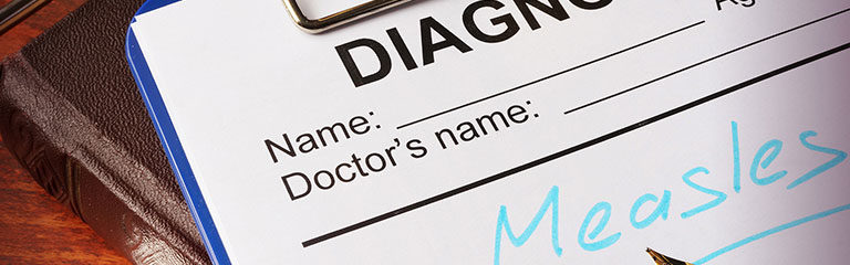 A photo a diagnosis form on a clipboard - diagnosis Measles