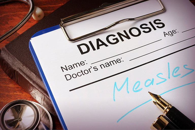 A photo a diagnosis form on a clipboard - diagnosis Measles